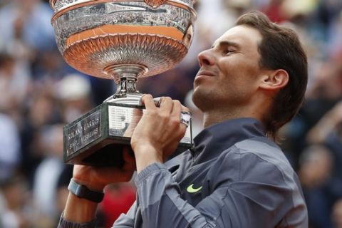 Spain's Rafael Nadal lifts the trophy as he celebrates his record 12th French Open tennis tournament title after winning his men's final match against Austria's Dominic Thiem in four sets, 6-3, 5-7, 6-1, 6-1, at the Roland Garros stadium in Paris, Sunday, June 9, 2019. (AP Photo/Christophe Ena)