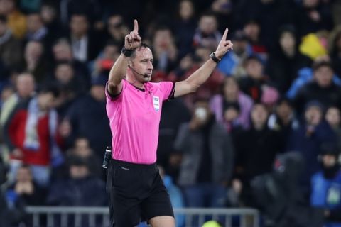 Referee Artur Dias gestures before watching the VAR monitor during a Champions League soccer match Group A between Real Madrid and Paris Saint Germain at the Santiago Bernabeu stadium in Madrid, Spain, Tuesday, Nov. 26, 2019. (AP Photo/Manu Fernandez)