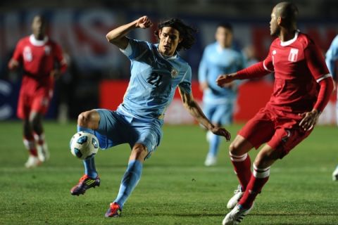 Uruguayan forward Edinson Cavani (L) controls the ball as Peruvian defender Alberto Rodriguez looks on during their 2011 Copa America Group C first round football match, at the Estadio del Bicentenario stadium in San Juan, 1126 Km west of Buenos Aires, on July 4, 2011.    AFP PHOTO / ALEJANDRO PAGNI (Photo credit should read ALEJANDRO PAGNI/AFP/Getty Images)