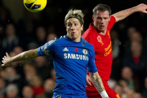 Chelsea's Fernando Torres, left, fights for the ball with Liverpool's Jamie Carragher during their English Premier League soccer match at the Stamford Bridge Stadium, London, Sunday, Nov. 11, 2012. (AP Photo/Tom Hevezi)