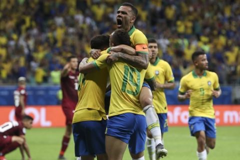 Brazil's Dani Alves, top, celebrates with teammates a goal by Philippe Coutinho that was later disallowed by the referee during a Copa America Group A soccer match at the Arena Fonte Nova in Salvador, Brazil, Tuesday, June 18, 2019. (AP Photo/Ricardo Mazalan)