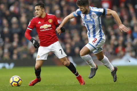 Manchester United's Alexis Sanchez, left, and Huddersfield Town's Tommy Smith, during their English Premier League soccer match at Old Trafford in Manchester, England, Saturday Feb. 3, 2018. (Martin Rickett/PA via AP)
