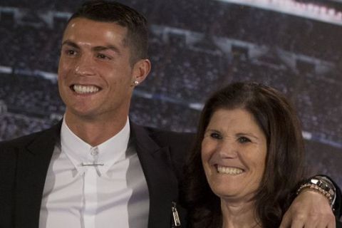 Real Madrid's Cristiano Ronaldo, center, poses his mother Maria Dolores dos Santos Aveiro, right and with the club's President Florentino Perez after signing a new contract at the Santiago Bernabeu stadium in Madrid, Spain, Monday, Nov. 7, 2016. Real Madrid have extend Ronaldo's contract until June 2021, when the three-time world player of the year will be 36. Financial details were not released, although the star forward is expected to remain the team's top-paid player. (AP Photo/Paul White)