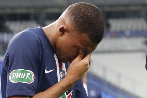 PSG's Kylian Mbappe holds his eyes after being tackled during the French Cup soccer final match between Paris Saint Germain and Saint Etienne at Stade de France stadium, in Saint Denis, north of Paris, Friday July 24, 2020. (AP Photo/Francois Mori)
