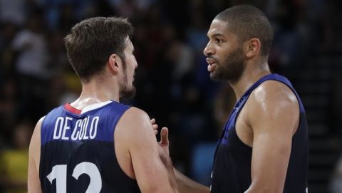 France's Nando de Colo (12) celebrates with teammate Nicolas Batum after a basketball game against Serbia at the 2016 Summer Olympics in Rio de Janeiro, Brazil, Wednesday, Aug. 10, 2016. (AP Photo/Charlie Neibergall)