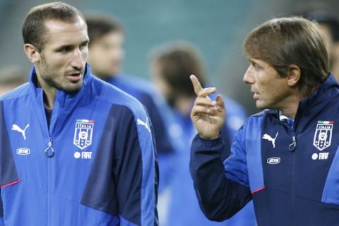 Italy's head coach Antonio Conte, right, talks to Giogio Chiellini, left, during a training session at the Olympic stadium in Baku, Azerbaijan, Friday, Oct. 9, 2015. Italy will play Azerbaijan in a Euro 2016 soccer qualifying group H match on Saturday, Oct. 10 in Baku. (AP Photo/Mindaugas Kulbis)