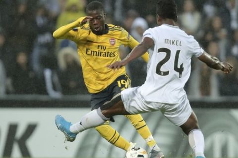 Vitoria's Mikel Agu vies for the ball with Arsenal's Nicolas Pepe, left, during the Europa League group F soccer match between Vitoria SC and Arsenal at the D. Afonso Henriques stadium in Guimaraes, Portugal, Wednesday, Nov. 6, 2019. (AP Photo/Luis Vieira)
