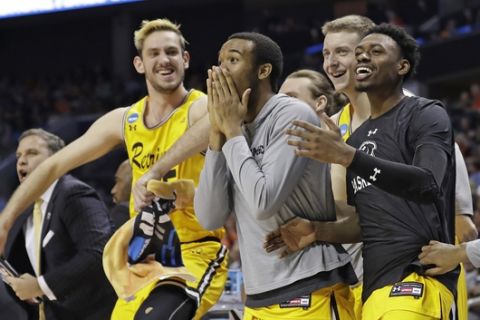 UMBC players celebrate a teammate's basket against Virginia during the second half of a first-round game in the NCAA men's college basketball tournament in Charlotte, N.C., Friday, March 16, 2018. (AP Photo/Gerry Broome)