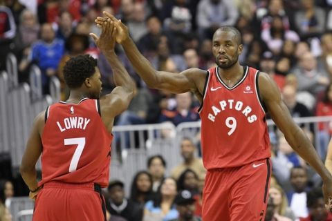 Toronto Raptors forward Serge Ibaka (9) gets a high five from guard Kyle Lowry (7) after he was fouled during the second half of an NBA basketball game against the Washington Wizards, Saturday, Oct. 20, 2018, in Washington. The Raptors won 117-113. (AP Photo/Nick Wass)