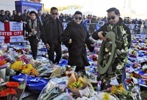 Aiyawatt Srivaddhanaprabha, the son of Vichai Srivaddhanaprabha, his mother Aimon, second left, and family members lay a wreath outside Leicester City Football Club, Leicester, England, Monday Oct. 29, 2018, after a helicopter crashed in flames Saturday. Vichai Srivaddhanaprabha, the Thai billionaire owner of Premier League team Leicester City was among five people who died after his helicopter crashed and burst into flames shortly after taking off from the soccer field, the club said Sunday. (AP Photo/Rui Vieira)