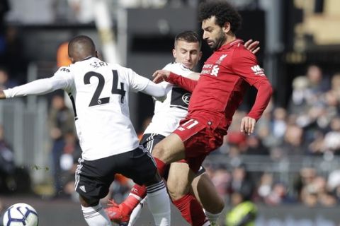 Liverpool's Mohamed Salah, right, vies for the ball with Fulham's Jean Michael Seri during the English Premier League soccer match between Fulham and Liverpool at Craven Cottage stadium in London, Sunday, March 17, 2019. (AP Photo/Kirsty Wigglesworth)