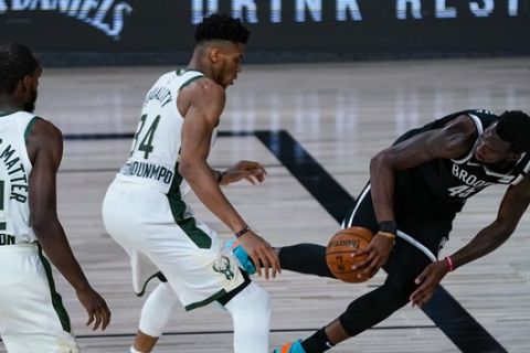 Brooklyn Nets forward Donta Hall, right, tries to save the ball in front of Milwaukee Bucks forward Giannis Antetokounmpo (34) during the first half of an NBA basketball game Tuesday, Aug. 4, 2020 in Lake Buena Vista, Fla. (AP Photo/Ashley Landis)