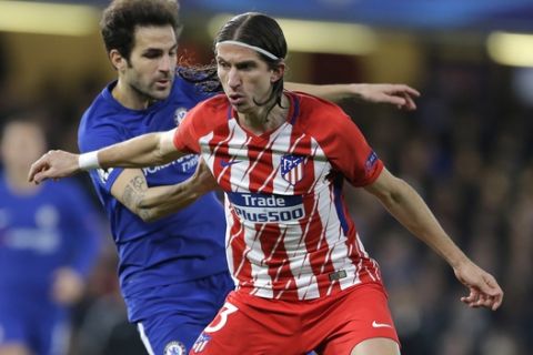 Chelsea's Cesc Fabregas, left, vies for the ball with Atletico's Filipe Luis during the Champions League Group C soccer match between Chelsea and Atletico Madrid at Stamford Bridge stadium in London Tuesday, Dec. 5, 2017. (AP Photo/Alastair Grant)