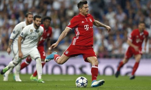 Bayern's Robert Lewandowski, center, scores his side's first goal form a penalty during the Champions League quarterfinal second leg soccer match between Real Madrid and Bayern Munich at Santiago Bernabeu stadium in Madrid, Spain, Tuesday April 18, 2017. (AP Photo/Francisco Seco)