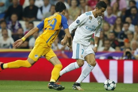 Real Madrid's Cristiano Ronaldo, right, and APOEL Nicosia's Praksitelis Vouros battle for the ball during a Champions League group H soccer match between Real Madrid and Apoel Nicosia at the Santiago Bernabeu stadium in Madrid, Spain, Wednesday, Sept. 13, 2017. (AP Photo/Paul White)