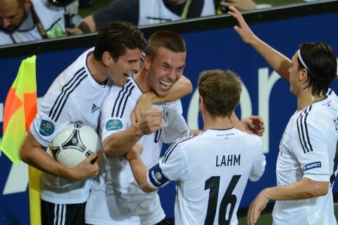 German forward Lukas Podolski  (2ndL) is congratulated by teammates after scoring a goal during the Euro 2012 football championships match Denmark vs. Germany, on June 17, 2012 at the Arena Lviv in Lviv. AFP PHOTO / PATRIK STOLLARZ        (Photo credit should read PATRIK STOLLARZ/AFP/GettyImages)