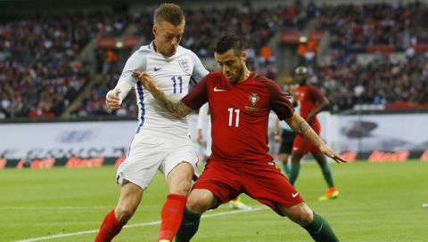 England's Jamie Vardy, left, competes for the ball with Portugal's Vieirinha during the international friendly soccer match between England and Portugal at Wembley stadium in London, Thursday, June 2, 2016. (AP Photo/Kirsty Wigglesworth)