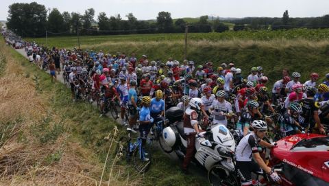 Riders wait on the road after a farmer's protest interrupted the sixteenth stage of the Tour de France cycling race over 218 kilometers (135.5 miles) with start in Carcassonne and finish in Bagneres-de-Luchon, France, Tuesday, July 24, 2018. (AP Photo/Peter Dejong)
