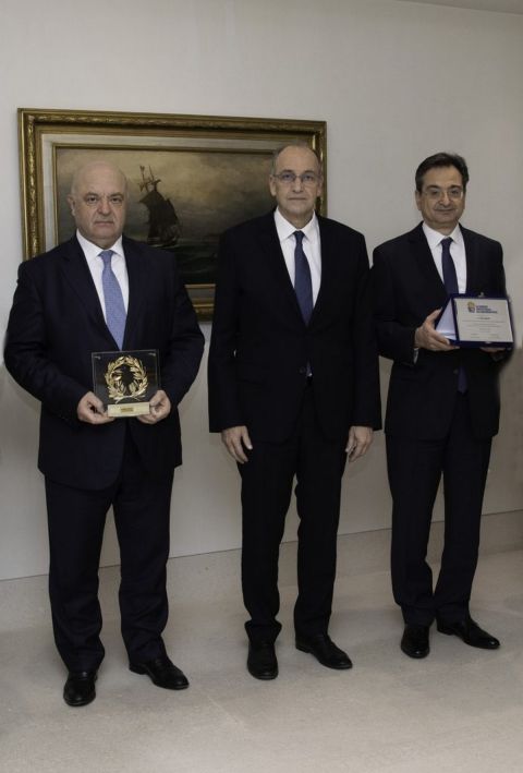 Ο Πρόεδρος του ΔΣ της EuroBank και ο Φωκίων Καραβίας παραλαμβάνουν τα αναμνηστικά από τον πρόεδρο της ΕΟΚ, Βαγγέλη Λιόλιο