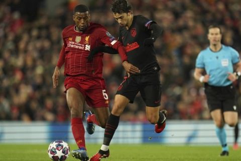 Liverpool's Georginio Wijnaldum, left, fights for the ball with Atletico Madrid's Joao Felix during a second leg, round of 16, Champions League soccer match between Liverpool and Atletico Madrid at Anfield stadium in Liverpool, England, Wednesday, March 11, 2020. (AP Photo/Jon Super)