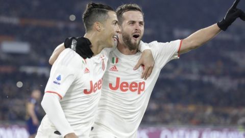 Juventus' Cristiano Ronaldo, left, celebrates with teammate Miralem Pjanic after scoring his side's second goal during the Serie A soccer match between Roma and Juventus at the Rome Olympic Stadium, Italy, Sunday, Jan. 12, 2020. (AP Photo/Andrew Medichini)