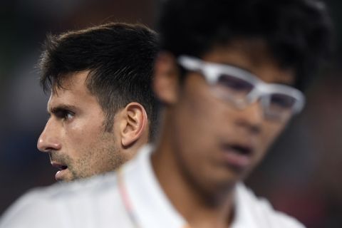 Serbia's Novak Djokovic, left, walks past his opponent South Korea's Chung Hyeon during their fourth round match at the Australian Open tennis championships in Melbourne, Australia, Monday, Jan. 22, 2018. (AP Photo/Andy Brownbill)