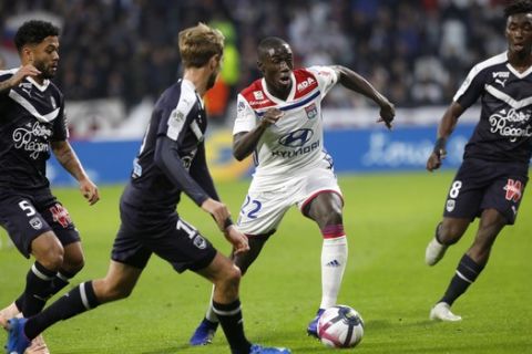 Lyon's Ferland Mendy, center, challenges for the ball with Bordeaux' players during their French League One soccer match in Decines, near Lyon, central France, Saturday, Nov. 3, 2018. (AP Photo/Laurent Cipriani)