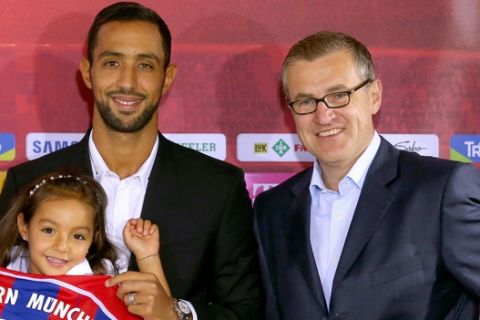 New Bayern Munich player Mehdi Benatia of Marocco, center, poses with his daughter Lina, Matthias Sammer , left, sporting director of FC Bayern Munich and Jan-Christian Dreesen, CFO of the Munich soccer club after a press conference at the soccer clup headquarters in Munich, Germany on Thursday Aug.28,2014.  (AP Photo/dpa/Alexander Hassenstein)