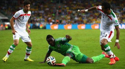 CURITIBA, BRAZIL - JUNE 16: Emmanuel Emenike of Nigeria competes for the ball with Alireza Jahan Bakhsh (L) and Mehrdad Pooladi of Iran (R) during the 2014 FIFA World Cup Brazil Group F match between Iran and Nigeria at Arena da Baixada on June 16, 2014 in Curitiba, Brazil.  (Photo by Julian Finney/Getty Images)