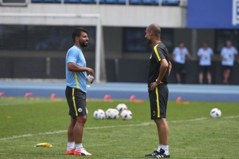 Manchester City's Sergio Aguero (L) chats with coach Pep Guardiola during a training session a day before the 2016 International Champions Cup football match between Manchester City and Manchester United, in Beijing on July 24, 2016. / AFP PHOTO / GREG BAKERGREG BAKER/AFP/Getty Images