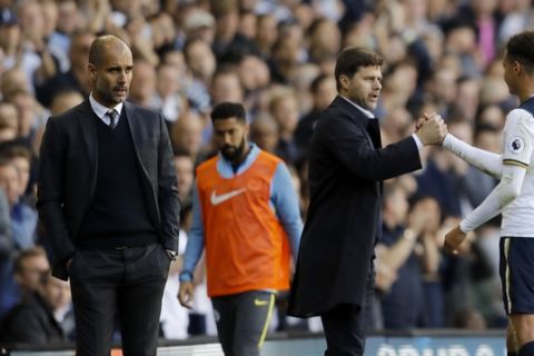 Manchester Citys manager Pep Guardiola, left, looks on as Tottenham Hotspurs Dele Alli, right, shakes hands with Tottenham Hotspurs manager Mauricio Pochettino as he is substituted during the Premier League soccer match between Tottenham Hotspur and Manchester City at White Hart Lane stadium in London, Sunday, Oct. 2, 2016. (AP Photo/Frank Augstein)