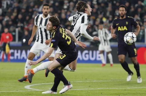 Juventus' Federico Bernardeschi is fouled by Tottenham's Ben Davies, left, in the penalty box, during the Champions League, round of 16, first-leg soccer match between Juventus and Tottenham Hotspurs, at the Allianz Stadium in Turin, Italy, Tuesday, Feb. 13, 2018. (AP Photo/Antonio Calanni)