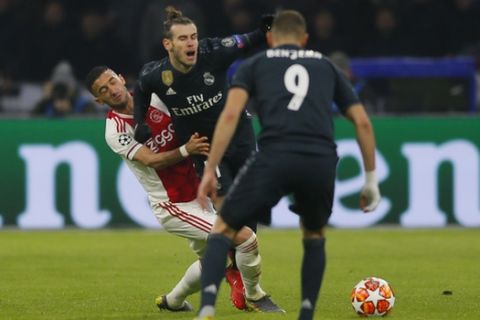 Real midfielder Gareth Bale, center, is tackled by Ajax's Hakim Ziyech, left, during the first leg, round of sixteen, Champions League soccer match between Ajax and Real Madrid at the Johan Cruyff ArenA in Amsterdam, Netherlands, Wednesday Feb. 13, 2019. (AP Photo/Peter Dejong)