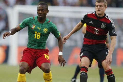 Germany's Toni Kroos, right, and Cameroon's Eyong Enoh challenge for the ball during a soccer friendly match between Germany and Cameroon in Moenchengladbach, Germany, Sunday, June 1, 2014. (AP Photo/Michael Probst)