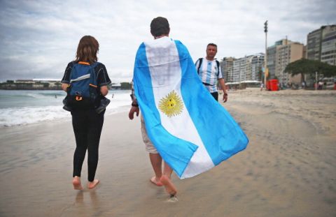 RIO DE JANEIRO, BRAZIL - JULY 11:  A fan wears an Argentine flag on Copacabana Beach ahead of their 2014 FIFA World Cup final match against Germany on July 11, 2014 in Rio de Janeiro, Brazil. Up to 100,000 Argentine fans are expected to arrive in Rio for the final match which will be held at the famed Maracana stadium on July 13.  (Photo by Mario Tama/Getty Images)