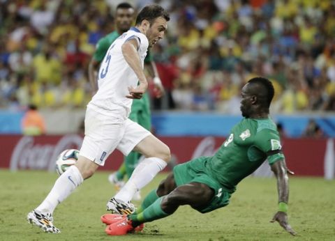 Ivory Coast's Cheik Tiote kicks the ball away on an attack by Greece's Vasilis Torosidis during the group C World Cup soccer match between Greece and Ivory Coast at the Arena Castelao in Fortaleza, Brazil, Tuesday, June 24, 2014. (AP Photo/Christophe Ena)