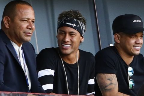 Paris Saint-Germain's, Brazilian soccer star Neymar, center, flanked by his father Neymar Santos, at left, watches the match at the Parc des Princes stadium in Paris, Saturday, Aug. 5, 2017, after his official presentation to fans ahead of Paris Saint-Germain's season opening match against Amiens. Neymar would not play in the club's season opener as the French football league did not receive the player's international transfer certificate before Friday's night deadline. The Brazil star became the most expensive player in soccer history after completing his blockbuster transfer from Barcelona for 222 million euros ($262 million) on Thursday. (AP Photo/Francois Mori)