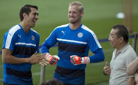 Leicester's Jose Ulloa, left and goalkeeper Kasper Schmeichel, center, laugh with the club's chairman Vichai Srivaddhanaprabha during a training session at the Vicente Calderon stadium in Madrid, Spain, Tuesday April 11, 2017. Leicester will play Atletico Madrid Wednesday in a Champions League quarterfinal, first leg soccer match in Madrid. (AP Photo/Paul White)