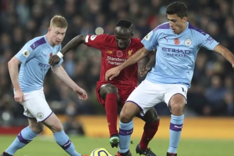 Liverpool's Sadio Mane, center, challenges for the ball with Manchester City's Kevin De Bruyne, and his teammate Rodrigo during the English Premier League soccer match between Liverpool and Manchester City at Anfield stadium in Liverpool, England, Sunday, Nov. 10, 2019. (AP Photo/Jon Super)