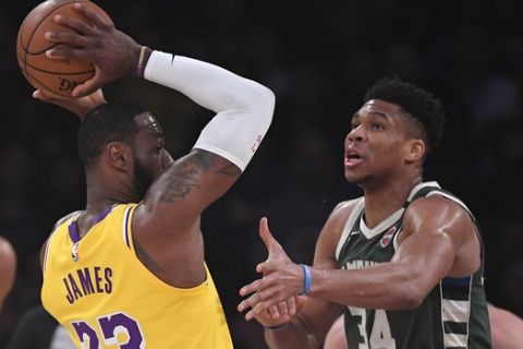 Los Angeles Lakers forward LeBron James, left, tries to pass as Milwaukee Bucks forward Giannis Antetokounmpo guards him during the first half of an NBA basketball game Friday, March 6, 2020, in Los Angeles. (AP Photo/Mark J. Terrill)