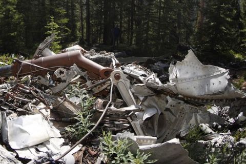 Family members sit amid the wreckage left from an airplane carrying some members of the Wichita State University Shockers football team that is scattered across the crash site near Loveland Pass Monday, July 27, 2020, west of Silver Plume, Colo. Wreckage from the plane, which was one of two being used to take the Shockers to play a football game against Utah State University in Logan, Utah, is still scattered on the mountain top nearly 50 years after the crash close to the Eisenhower Tunnel. (AP Photo/David Zalubowski)