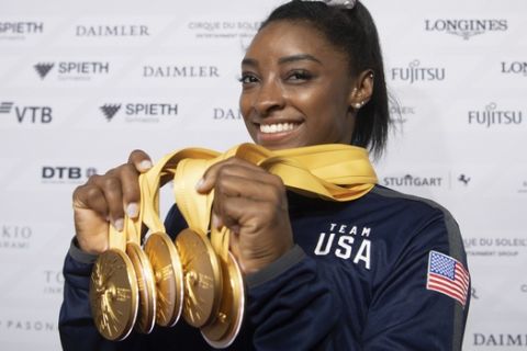 Simone Biles of the United States shows her five gold medals she won at the Gymnastics World Championships in Stuttgart, Germany, Sunday, Oct. 13, 2019. (Marijan Murat/dpa via AP)