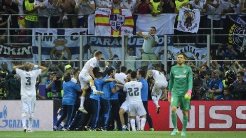 Real Madrid players celebrate with supporters after they won the UEFA Champions League final football match over Atletico Madrid at San Siro Stadium in Milan, on May 28, 2016. / AFP / OLIVIER MORIN        (Photo credit should read OLIVIER MORIN/AFP/Getty Images)