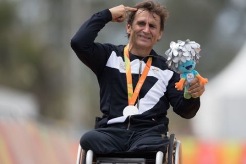 Italy's silver medalist Alessandro "Alex" Zanardi poses for photos during the medal ceremony for the men's road race H5 hand-cycling event, during the Paralympics Games, in Rio de Janeiro, Brazil, Thursday, Sept. 15, 2016. (AP Photo/Mauro Pimentel)