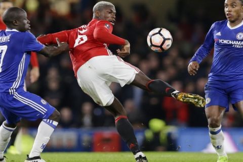 Manchester United's Paul Pogba kicks at the ball as Chelsea's N'Golo Kante, left, and Willian, right, watch during the English FA Cup quarterfinal soccer match between Chelsea and Manchester United at Stamford Bridge stadium in London, Monday, March 13, 2017 (AP Photo/Alastair Grant)
