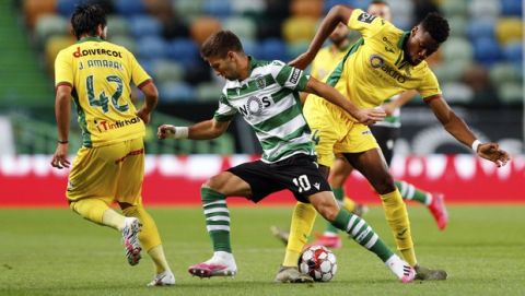 Sporting's Luciano Vietto vies for the ball with Pacos de Ferreira's Joao Amaral, left, and Mohamed Diaby during the Portuguese League soccer match between Sporting CP and Pacos de Ferreira at the Jose Alvalade stadium in Lisbon, Portugal, Friday, June 12, 2020. The Portuguese League soccer matches are being played without spectators because of the coronavirus pandemic. (Antonio Cotrim/Pool via AP)