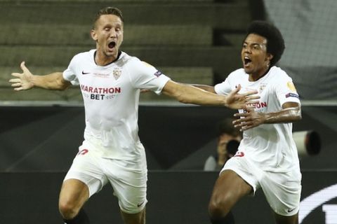 Sevilla's Luuk de Jong, left, celebrates after scoring his side's second goal during the Europa League final soccer match between Sevilla and Inter Milan in Cologne, Germany, Friday, Aug. 21, 2020. (Lars Baron, Pool Photo via AP)