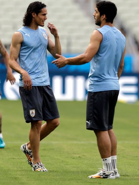 Uruguay's Edinson Cavani, left, speaks with teammate Luis Suarez during a training session at Arena Castelao in Fortaleza, Brazil, Friday, June 13, 2014. Uruguay will play a World Cup game on June 14. (AP Photo/Fernando Llano)