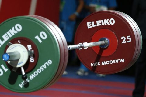 Dimitris Minasidis, of Cyprus shouts out as he drops the weights after a successful lift during the men's 62 weightlifting contest at the Commonwealth Games Glasgow 2014, in Glasgow, Scotland, Friday, July, 25, 2014. Minasidis went on to win the gold medal.(AP Photo/Alastair Grant)
