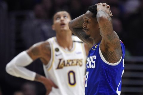 Los Angeles Clippers guard Lou Williams, reacts after they were called for a foul as Los Angeles Lakers forward Kyle Kuzma stands in the background during the second half of an NBA basketball game Sunday, March 8, 2020, in Los Angeles. The Lakers won 112-103. (AP Photo/Mark J. Terrill)